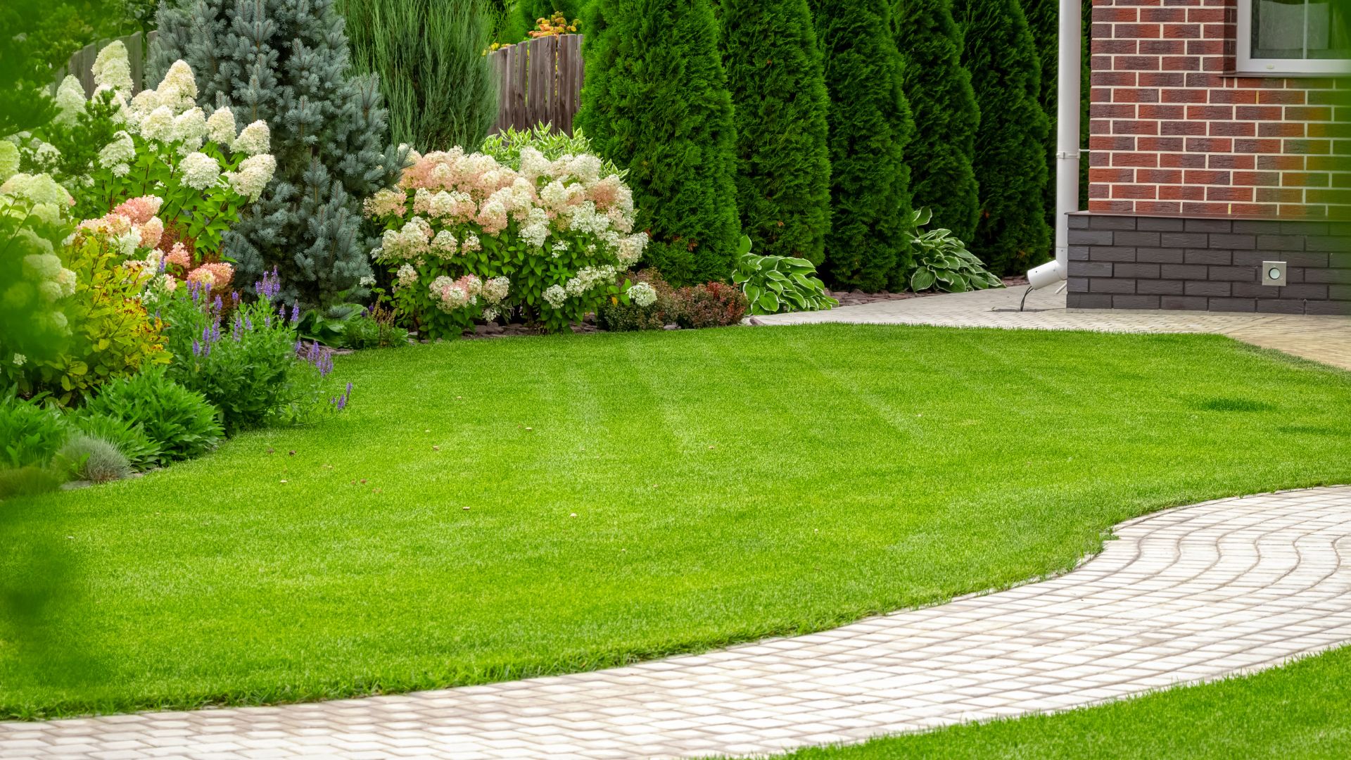 A green lawn with a brick path in the middle of it